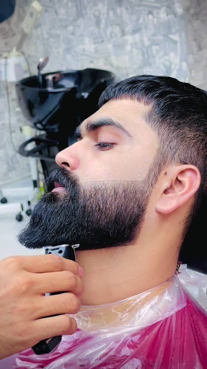 Long full beard being shaped with a trimmer