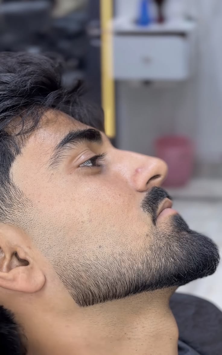 Side profile of a sculpted, sharply lined beard
