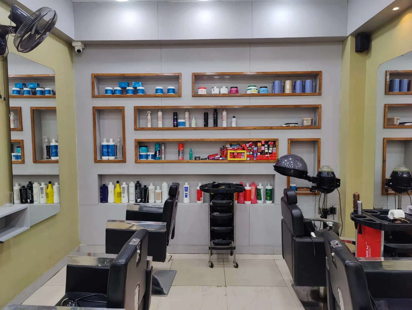 Shelves of hair and grooming products beside the styling chairs at Express Cuts, KR Puram