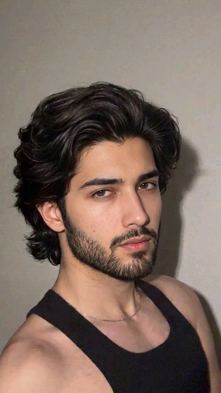 Shoulder-length layered wolf cut with a full beard